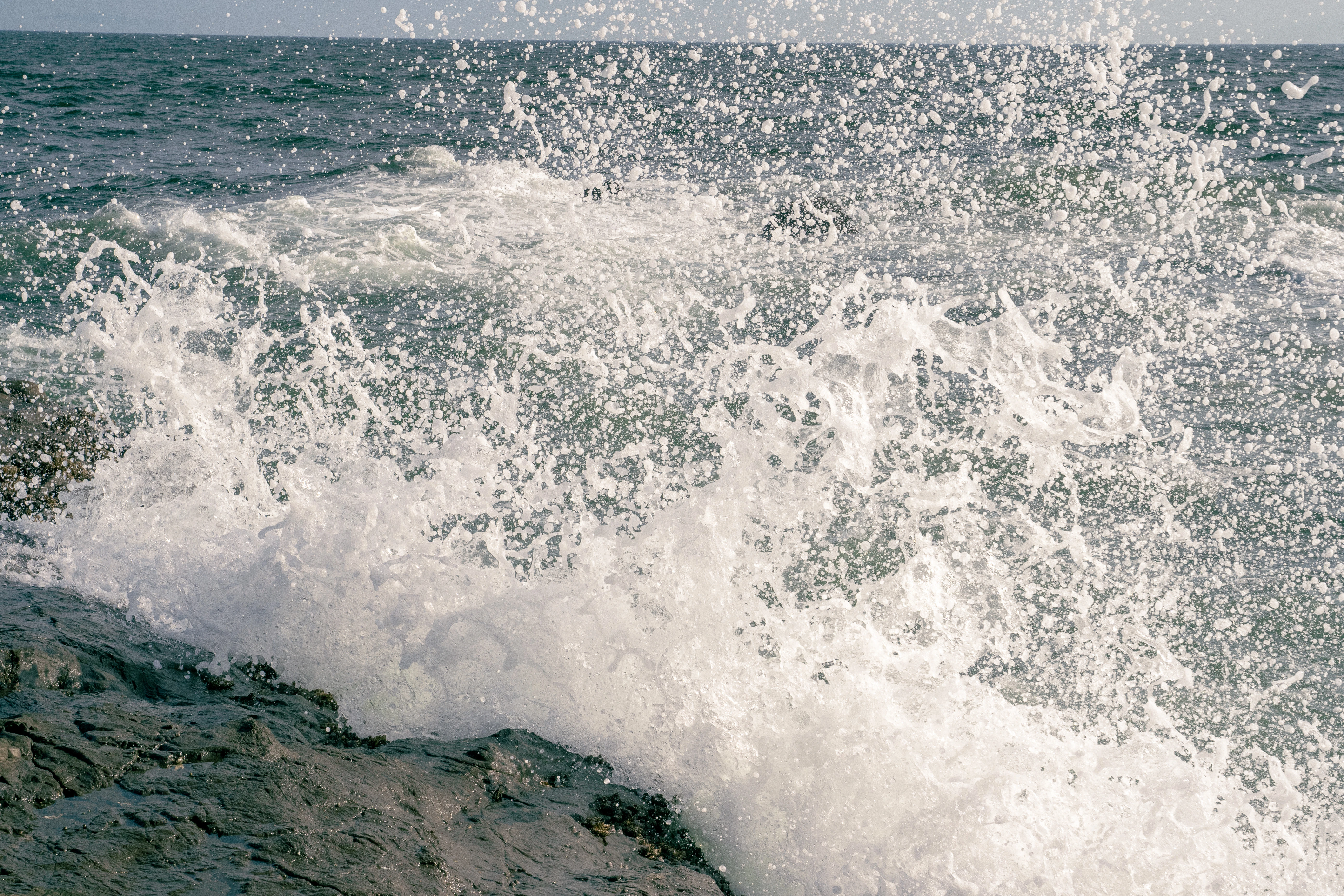 Dynamic Wave Splash Captured on a Rocky Shore